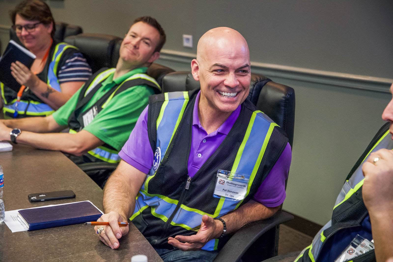 Smiling employees sit at a conference table together